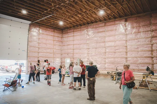 People visiting the under-construction interior of the Epic Youth Center.