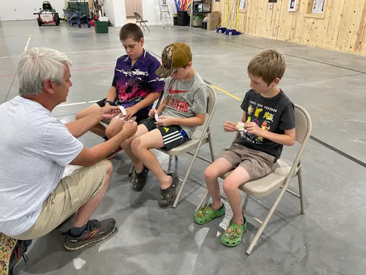 Instructor showing three youth how to open and apply adhesive bandages