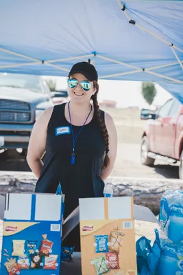 A volunteer with refreshments smiling at the camera.