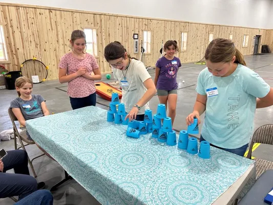 Kids making towers of stacked blue cups