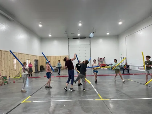 Youth with sticks attempting to hit a balloon