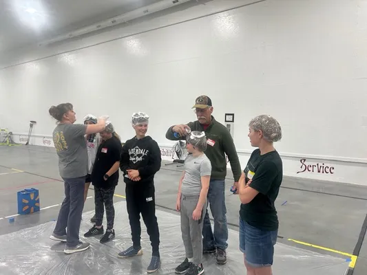 Youth in a line with cream sprayed on their heads