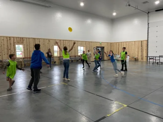 Youth playing indoor frisbee