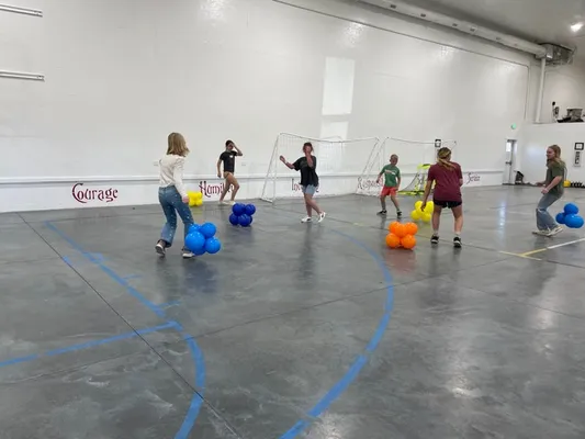 Youth playing with colored balloon clusters