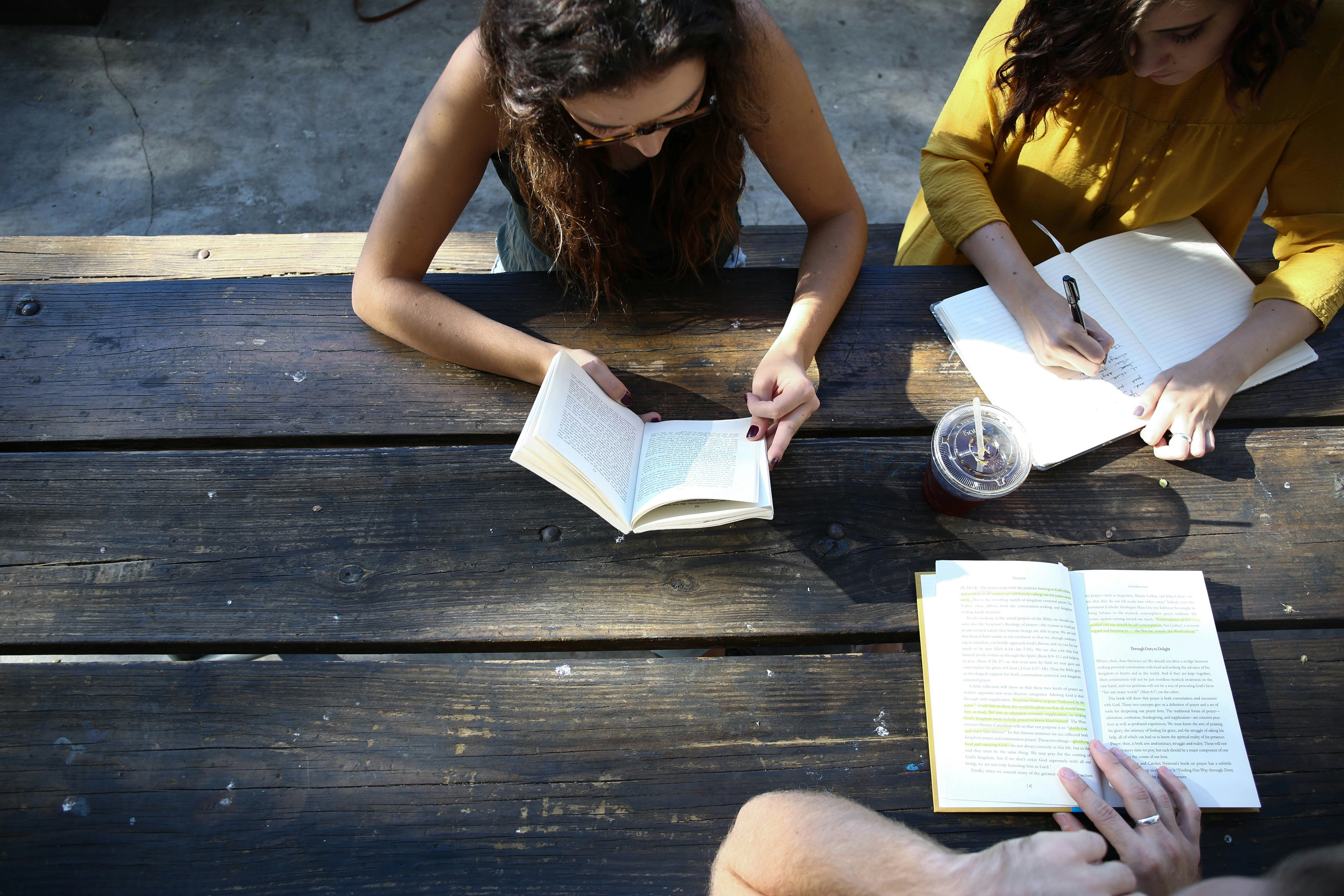 Youth studying books on a picnic table