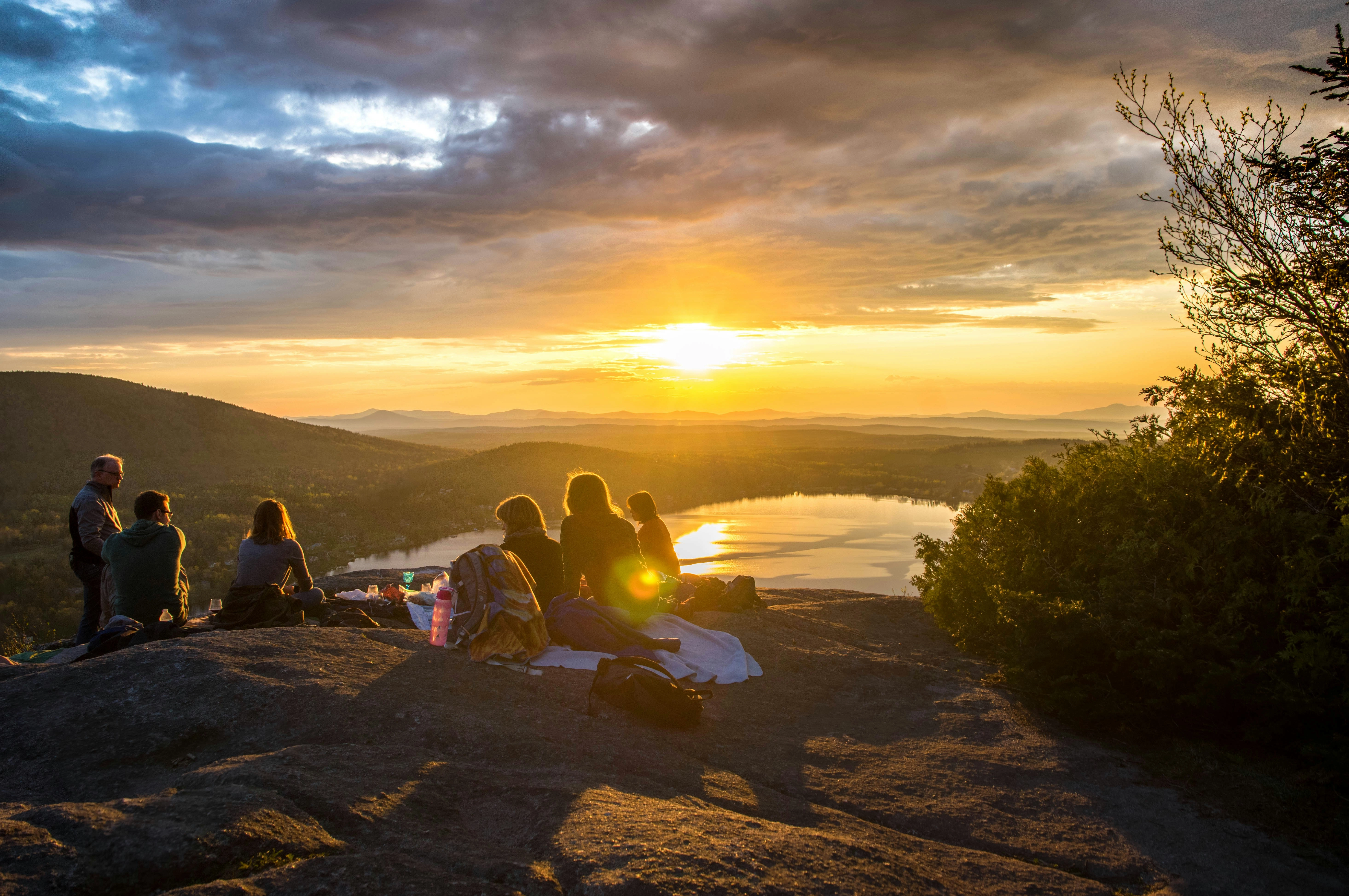 Youth picnicing at an overlook during the sunset