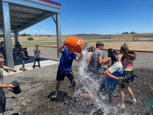 Dumping a container of water on youth.