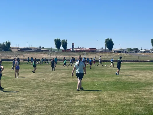 Youth on the soccer field with the goal in the distance.