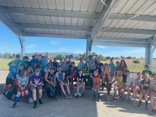 A large group of youth gathered under cover for a picture.