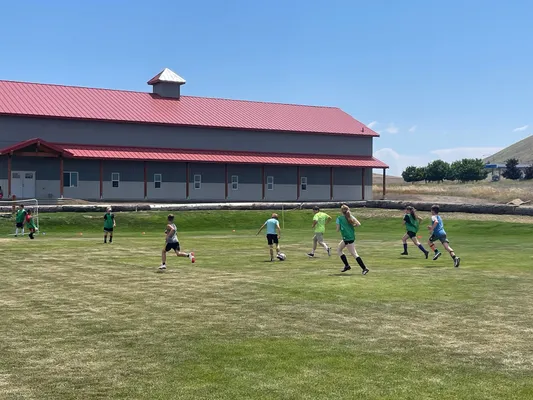 Youth playing soccer in front of the youth center.