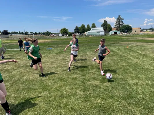 Youth chasing a soccer ball.