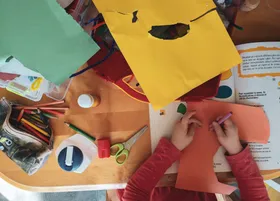 A youth coloring on colored paper