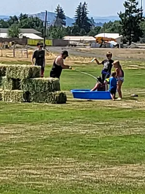 Volunteers filling a small pool with water.